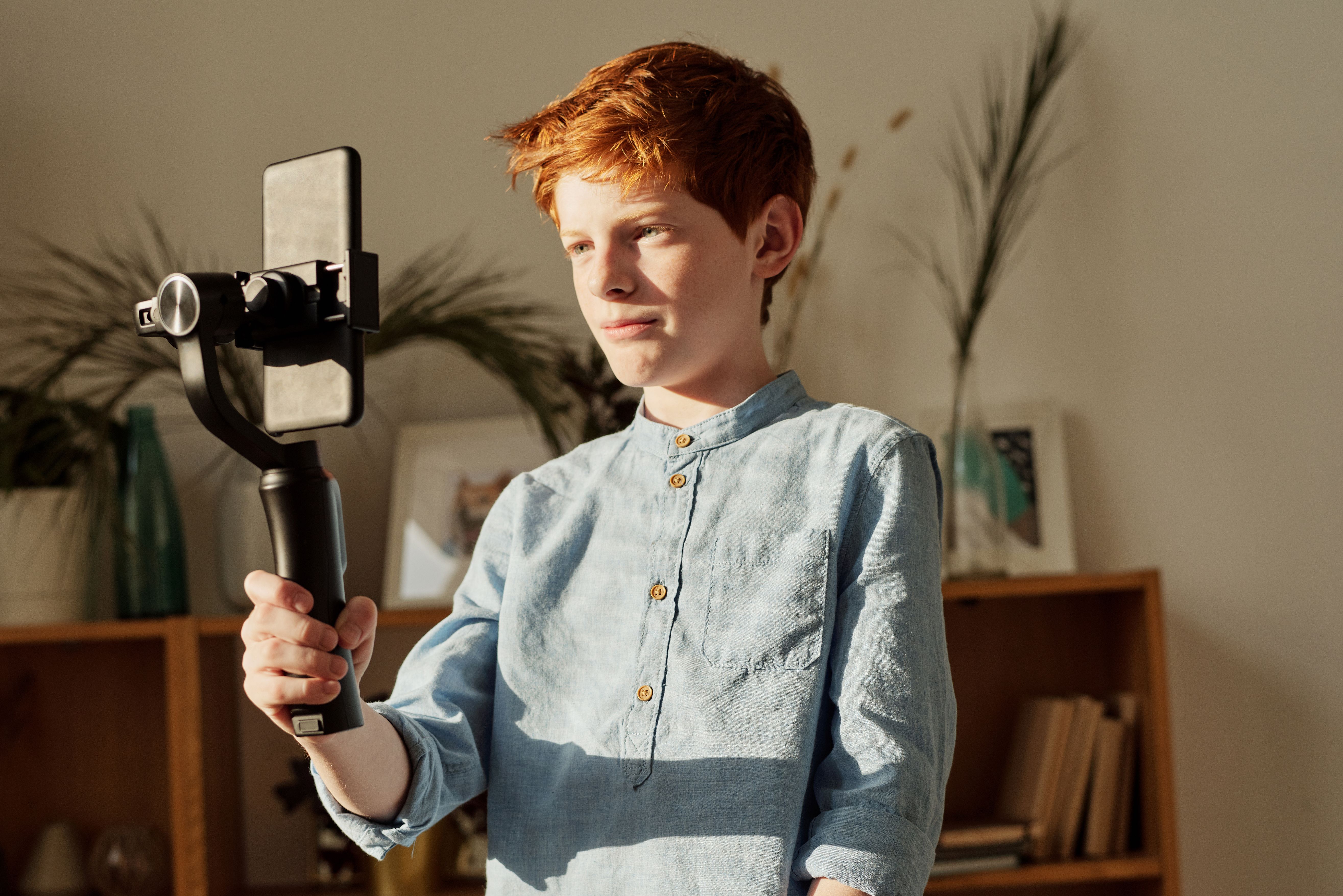 Un adolescent filme une audition self-tape à la maison avec un téléphone sur trépied